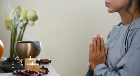 side-view-woman-praying-front-candles